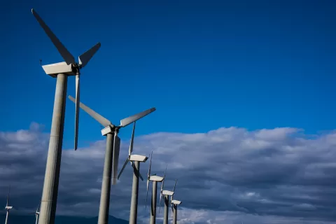 photo of a line of wind turbines against the sky