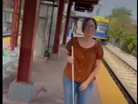 Sheila Koenig holding white cane at light rail station
