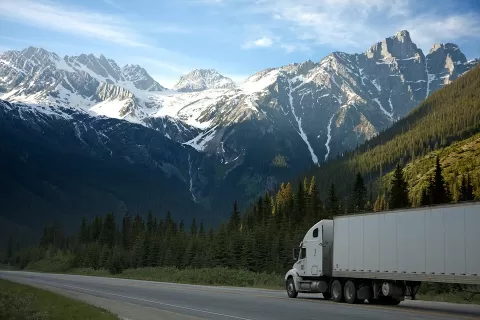 semi truck driving on mountain highway