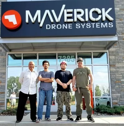 photo of four people standing in front of a business building