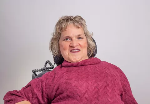 Smiling person in a pink sweater