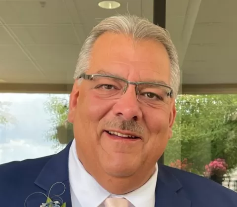 smiling man wearing glasses and a suit and tie
