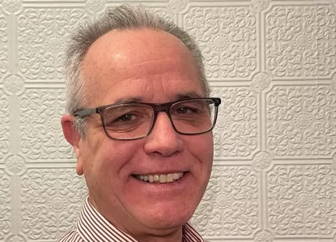 smiling man wearing glasses and button-down shirt