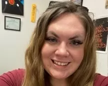 photo of Jenny, a smiling woman with long hair wearing a red shirt