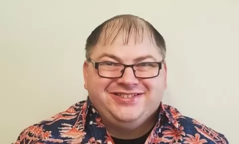 a smiling man wearing glasses