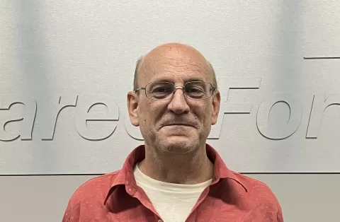 smiling person wearing glasses and a red shirt