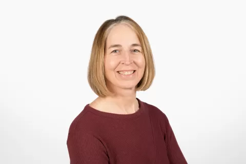photo of smiling person in maroon shirt