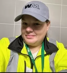 smiling person wearing baseball cap and reflective jacket