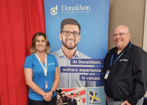 two people standing in front of a banner that says Donaldson Company