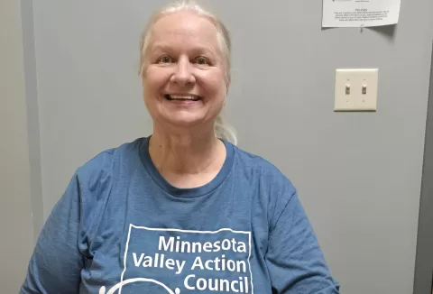 photo of smiling person wearing a blue t-shirt with the words 'Minnesota Valley Action Council'