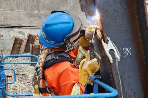 person wearing a helmet and gloves welding a piece of metal