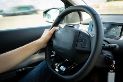 photo of hand on car steering wheel