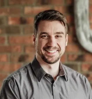 photo of a smiling person wearing a grey shirt