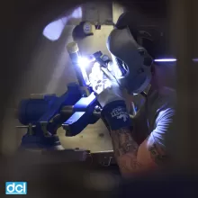 photo of person working with light and magnification to make a metal component