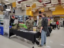 many people in a very large room with tables holding display materials