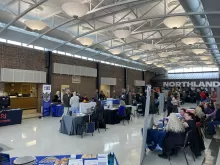 many people in a very large room with tables lining the walls