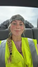 photo of smiling person wearing a bright yellow vest